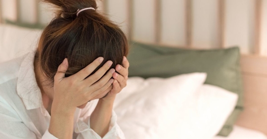 woman holding her head in her hands