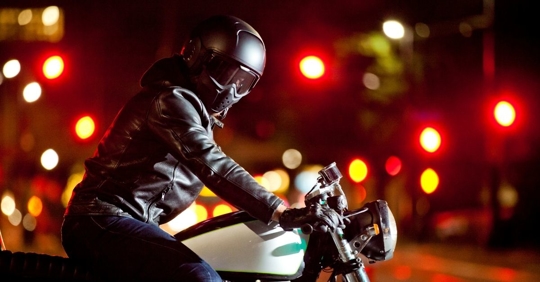 motorcycle rider wearing a helmet, goggles, and a leather jacket