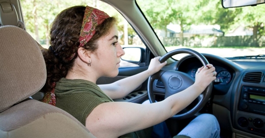 view of a teen driver from the backseat
